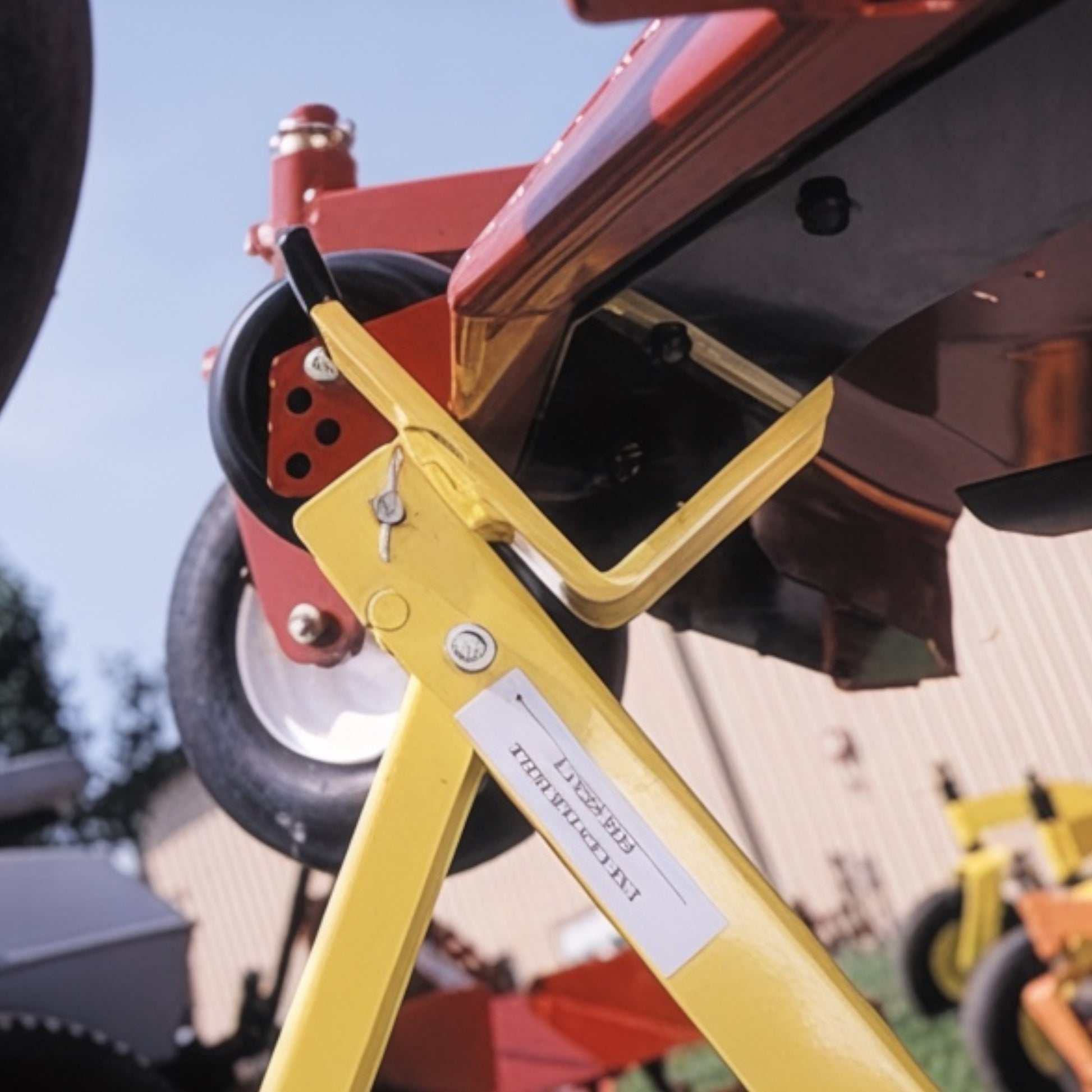 Side view of a mower lift tool lift arm secured under a mower deck.